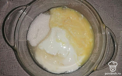 В глубокой тарелке смешайте сметану, оставшийся сахар и яйцо, и тщательно взбейте массу с помощью миксера.