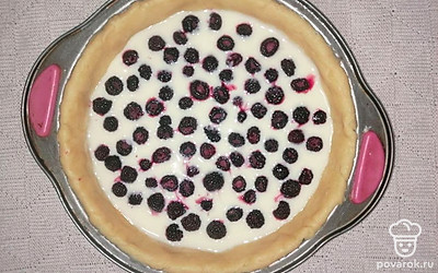 В форму с уложенным тестом влейте яично-сметанную смесь и равномерно распределите ягоды ежевики. Пирог поставьте в духовой шкаф и выпекайте при температуре 180°С в течение 30-35 минут.