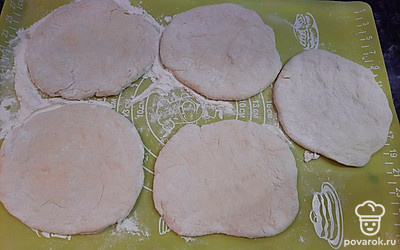 Разделяем тесто на равные куски. Скатываем тесто в шарики, шарики скалкой раскатываем в круглые лепешки, пересыпая мукой. 