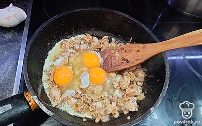 В горячую курицу на сковороду добавляем сырые яйца, перемешиваем, поддерживаем нагрев, пока яйца не свернутся. 