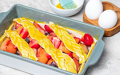 Завершите приготовление. Нарежьте оставшееся тесто тонкими полосками и сплетите из них косички. В произвольном порядке украсьте верх пирога. Смажьте поверхность желтком. Поставьте форму в духовку на 40 минут. Прежде чем достать из формы, дайте немного остыть.