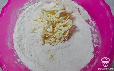 Муку смешайте с разрыхлителем и сахаром в миске. Натрите к ним масло и перетрите его с сухой смесью до крошки.