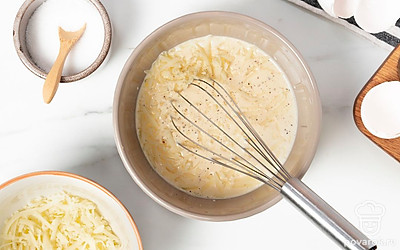 Приготовьте заливку для пирога. Взбейте яйца. Влейте к ним сливки, добавьте тертый сыр и перемешайте. Посолите и поперчите заливку.