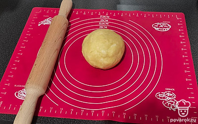 Большой кусочек теста раскатайте в круг и выложите его в предварительно смазанную форму для выпечки.