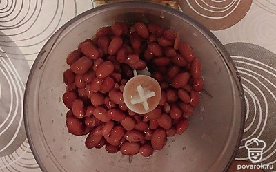 Откройте банку фасоли, слейте лишнюю жидкость. Выложите фасоль в блендер.