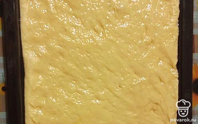 Переложите тесто в форму (22 на 30 сантиметров), предварительно смазанную и застеленную бумагой.