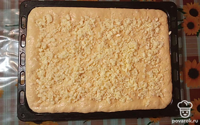 Наше тесто поднялось. Сделайте в нем углубления по всему пирогу и посыпьте крошкой.