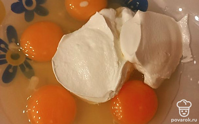 В миску разбиваем 4 яйца, добавляем к ним 150 г сметаны. Перемешиваем.