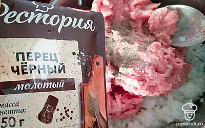 К рису переложите фарш. Добавьте соль, черный молотый перец и хорошо перемешайте.