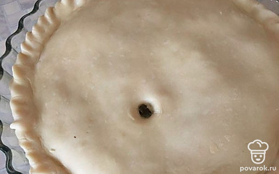 Накройте второй частью теста, защипните края пирога и сделайте небольшое отверстие сверху. Сверху пирог смажьте молоком.