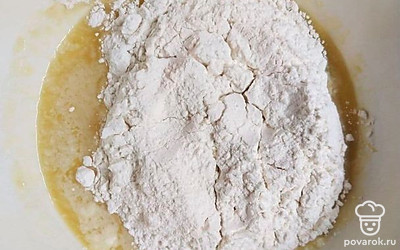 В масляную смесь постепенно введите муку, смешанную с разрыхлителем. Затем в тесто добавьте взбитые белки и аккуратно перемешайте лопаточкой.