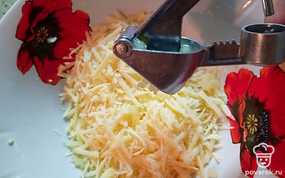 Чеснок почистите и пропустите через пресс. Соедините с сыром.