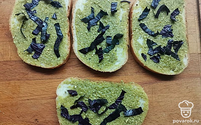 Ломтики свежего батона намажьте соусом песто и посыпьте нарезанным базиликом, чтобы вкус бутербродов стал еще ярче. 