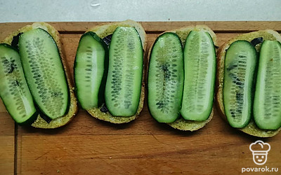 Сверху выложите тонкие слайсы свежего огурца. 