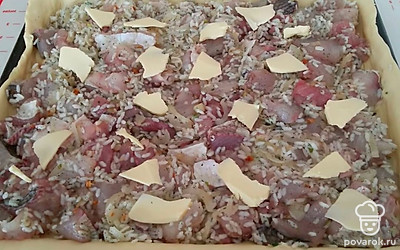 Готовое тесто раскатайте по форме для запекания. Сверху выложите слой начинки и небольшие кусочки сливочного масла для сочности.