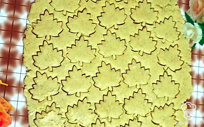 В оставшееся тесто добавьте муку, вымесите, пока не перестанет прилипать к рукам. Раскатайте пласт толщиной 0,5 см и вырежьте кленовые листья. Выложите листья на пирог и поставьте блюдо в духовку на 40 минут при температуре 190°С.