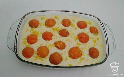 Форму для запекания смажьте растительным маслом, присыпьте манкой и вылейте тесто. Сверху на тесто выложить дольки абрикоса и натрите цедру лимона. Отправьте форму в разогретую духовку до 180°C на 40-45 минут.