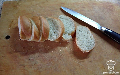 Батон нарежьте ломтиками примерно 1 сантиметр толщиной.