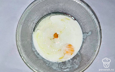 Замешайте тесто. Для этого возьмите удобную глубокую миску с высокими бортами и вылейте в нее кефир. Добавьте 2 яйца и растопленное сливочное масло. Перемешайте все ложкой.