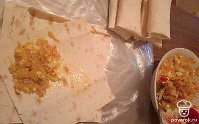 Лаваш разрежьте на квадраты (у меня получилось 12 шт), смажьте сметаной (так лаваш будет гибким). Выложите начинку и сверните конвертом.