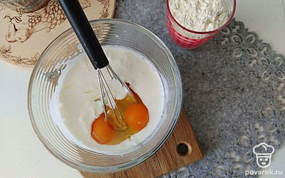 Кефир и яйца взбейте венчиком, добавьте сметану, муку и разрыхлитель. Тщательно перемешайте.