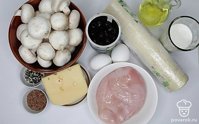 Готовое слоеное тесто разморозьте. Куриное филе ополосните под холодной водой, обсушите бумажным полотенцем. Нарежьте мясо кубиками 2 – 3 см. Грибы помойте, просушите, обновите срез на ножке, если они крупные, снимите жесткую кожицу со шляпок. Шампиньоны мелко порубите. Сыр натрите на крупной терке. Маслины нарежьте кружочками.