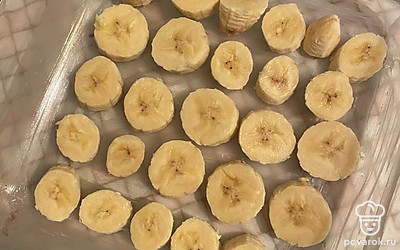 Бананы очистите и нарежьте на кругляшки 2 см толщиной. В форму для запекания, смазанную сливочным маслом, выложите бананы, затем влейте тесто. Распределите и отправьте запекаться в разогретую до 180 °С духовку на 35-40 минут.