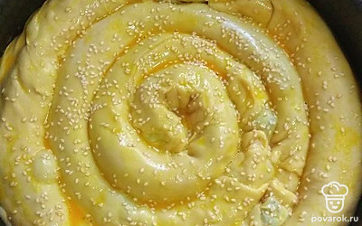 Рулетики сворачивайте в форме по типу улитки. Пирог сверху смажьте желтком и поставьте в разогретую до 180˚C духовку на 40 минут.