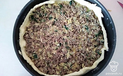 Достаньте тесто, отделите от него треть. Большую часть раскатайте, подпыляя мукой. Перенесите в форму (диаметром 24 см). Края подрежьте, излишки вмесите в маленький комок. Выложите начинку.