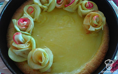 Яблочки нарежьте тонкими кружочками. В сотейник налейте стакан воды, положите 2 стакана сахара и доведите до кипения. Поместите в сироп яблоки на 1 минуту. Затем сверните их в розочки и украсьте ими пирог.