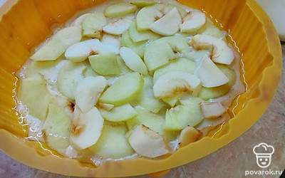 Вылейте половину массы в смазанную подсолнечным маслом форму, сверху выложите нарезанное ломтиками яблоко и залейте оставшейся смесью. Поставьте в духовку на 50 минут при температуре 180 °С.