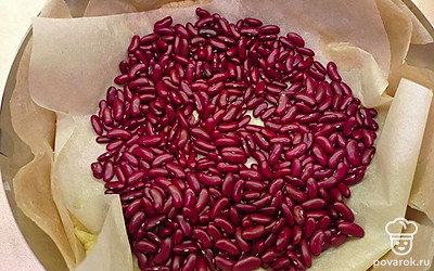 Застелите этим коржиком форму для запекания, сформируйте бортики, лишнее обрежьте. Сделайте проколы вилкой по всему периметру теста. Сверху накройте пергаментом, и распределить примерно 1 стакан сырой фасоли для веса. Выпекайте в разогретой до 180 °C духовке 17-20 минут.