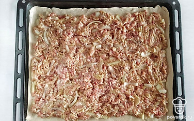 Поделите тесто на два пласта. Выложите один пласт на противень, ровным слоем распределите начинку. Накройте вторым пластом и защипните края пирога. Смажьте пирог яичным желтком, посыпьте кунжутом, выпекайте в разогретой духовке 50 минут при температуре 180С.