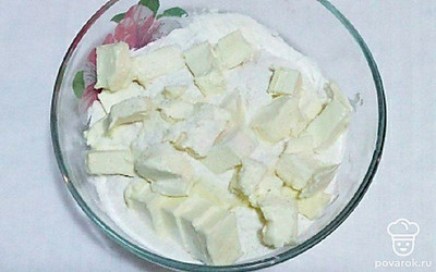 Смешайте муку, щепотку соли и нарезанное холодное масло, перетрите в крошку. Затем постепенно влейте воду и вымесите тесто. Получившееся тесто распределите по форме, в которой планируете выпекать и отправьте в холодильник на то время, пока будет готовиться начинка и заливка.