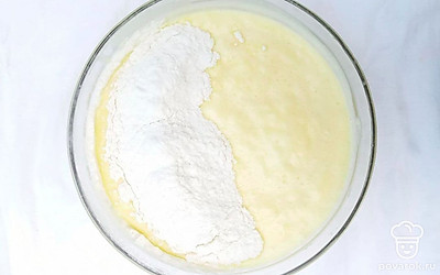 Добавьте к общей массе просеянную муку и перемешивайте аккуратно, но не слишком долго, чтобы получился воздушный бисквит. Готовое тесто вылейте на застеленный пекарской бумагой противень.