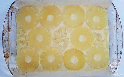 На бисквитное тесто выложите кольца ананасов так, чтобы не оставалось больших кусков свободного пространства. Выпекайте пирог в разогретой до 180℃ духовке около 20 минут.