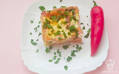 Готовый киш с лососем порежьте на порционные кусочки. Оформите блюдо, посыпав его рубленной зеленью.