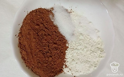 Затем, в отдельную миску добавьте сухие ингредиенты: муку, какао, соль, и ванильный сахар, все перемешайте. Постепенно добавляйте сухую смесь в тесто, взбивая миксером. Тесто должно получится довольно густое.