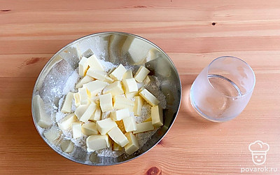 Просейте муку, нарежьте кубиками сливочное масло. Добавьте немного ледяной воды и замесите тесто. Поставьте в морозилку на полчаса.