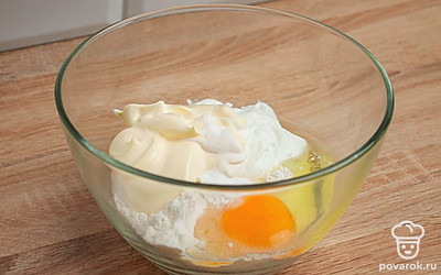 Возьмите глубокую миску. Смешайте в ней разбитое куриное яйцо, сметану, майонез, муку и разрыхлитель. Добавьте щепотку соли.