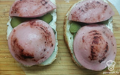 Выложите на бутерброды обжаренную колбасу. 