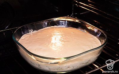 Испеките пирог. Разогрейте духовку до 180 градусов. Форму для выпечки застелите пергаментной бумагой или смажьте форму растительным маслом. На дно формы вылейте около трети теста и лопаточкой равномерно распределите по всей форме. Сверху разложите начинку из капусты. Затем залейте все оставшимся тестом. Поставьте в духовку пирог на 40 минут. Его готовность определите по корочке — она станет коричневой.