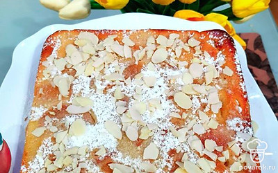 Украсьте десерт сахарной пудрой и лепестками миндаля.