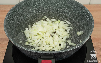 Разогрейте растительное масло в сковороде. Обжарьте репчатый лук в течение 5 минут на среднем огне до золотистости.