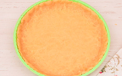 Готовое тесто достаньте из холодильника и раскатайте до толщины 3-4 мм. Выложите тесто в форму для пирога и аккуратно распределите, формируя бортики. Неровные края отрежьте.