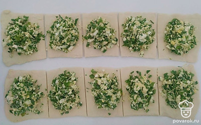Смешайте сыр, яйца, зелень и творог. Распределите полученную массу на заготовки. Сверху укройте прямоугольниками и прижмите края вилкой. Сверху сделайте несколько проколов, чтобы тесто, во время готовки, не пузырилось.