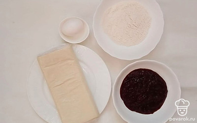 Слоеное тесто разморозьте при комнатной температуре, разложив его пластины в один слой на столе. Смородиновый джем достаньте из банки.