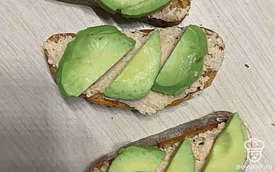 Сверху выложите тонко нарезанный авокадо.