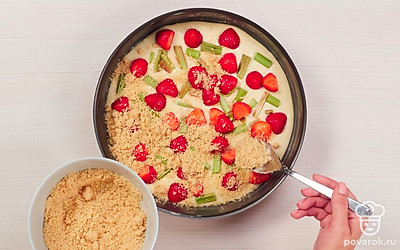 Выпеките пирог. Разогрейте духовку до 170 градусов. Дно формы для выпекания пирога застелите пергаментом для выпечки. В форму вылейте тесто, разровняйте и распределите сверху клубнику и ревень. Присыпьте пирог крошкой и выпекайте в духовке примерно 45-50 минут.