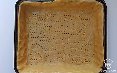 Раскатайте тесто размером с диаметр формы и плюс несколько дополнительных сантиметров на бортики. Выложите тесто в форму, подравняйте бортики и наколите дно вилкой, затем отправьте форму в холодильник на 10 минут.